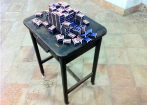 Instalação Irreprodutiblidade, 2014. Mesa antiga pequena com caixas de fósforo. Arte de Bactéria.